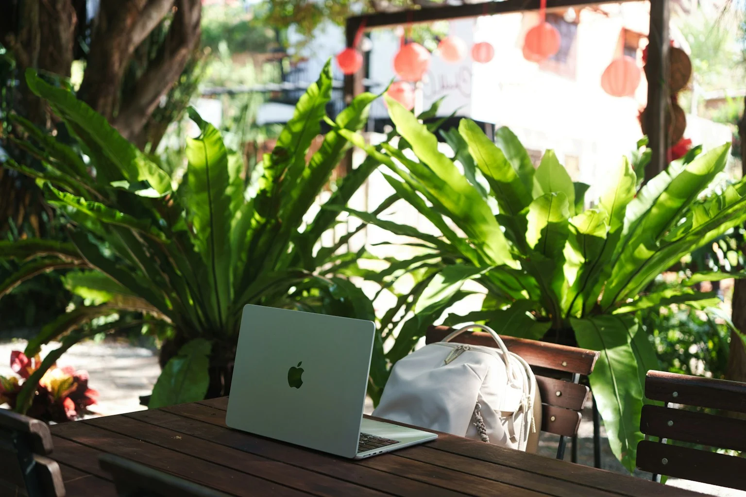 Laptop at an outdoor tropical workspace surrounded by plants